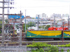 08 - Os trens de carga, a malha ferroviária, as torres de alta tensão e a pressa diária. À esquerda, operários mantêm as linhas nos intervalos das passagens dos trens.
